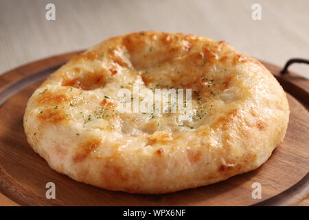 Focaccia pane pizza closeup isolato su una lastra di legno sul tavolo Foto Stock