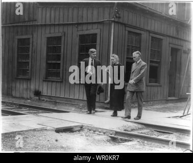 Marie Curie, 1867-1934, ritratto a figura intera, in piedi tra due uomini Foto Stock