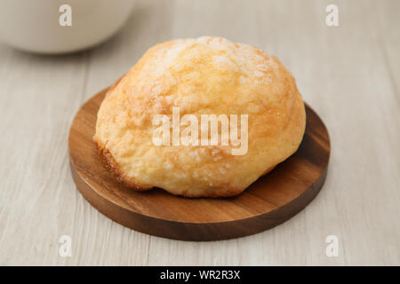 Pane di zucchero melon pan su piastra in legno coltello forcella closeup isolato sul tavolo Foto Stock