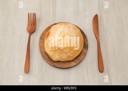 Pane di zucchero melon pan su piastra in legno coltello forcella closeup isolato sul tavolo Foto Stock