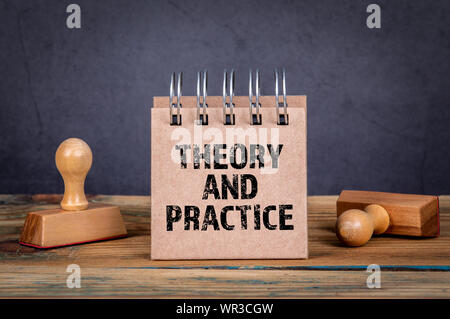 La teoria e la pratica. Blocco note su sfondo scuro Foto Stock