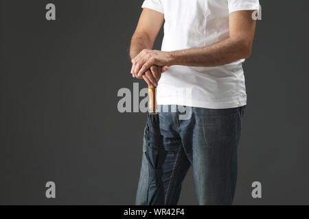 Midsection view of an old man holding umbrella Stock Photo