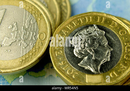 Pila di British pound monete accanto a una delle monete in euro nel caso in cui sia visibile solo la mappa dell'UE. Illustra il fatto che il Regno Unito a lasciare l'UE. Foto Stock