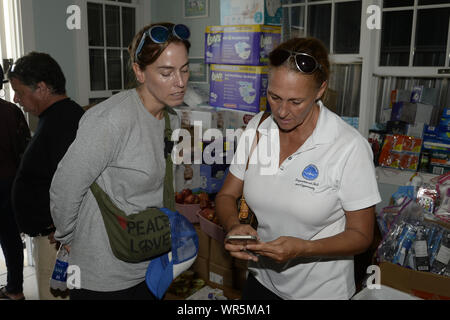 Treasure Cay, Bahamas. Il 9 settembre 2019. Christina Henley (r) gli scambi di informazioni di contatto con Angie Wagner di CADENA a Treasure Cay nelle Bahamas il 9 settembre 2019. Ms Henley ha fornito il coordinamento e la logistica per 'Shipwreck Park", un 501 (c) (3) corporation che è responsabile per l'accettazione e la distribuzione di beni, materiali di consumo e forniture mediche per la catena di isole. Credito: UPI/Alamy Live News Foto Stock