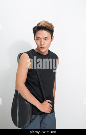 Asian badminton player con borsa su sfondo bianco Foto Stock