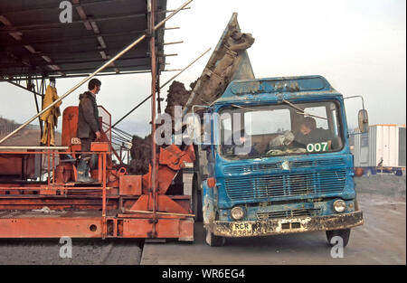 Archiviazione di ribaltamento laterale del carrello camion offrire calcestruzzo bagnato dal sito di impianto di dosaggio per strada macchina posa su originali M25 costruzione autostradale Essex REGNO UNITO Foto Stock