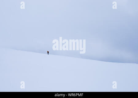 Persona non identificabili camminando verso Storsteinen vertice di montagna e il picco nella neve tra il meraviglioso paesaggio invernale, Norvegia Foto Stock