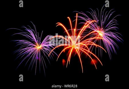 Le esplosioni e le pulegge scanalate colorata formando uno spettacolo di fuochi d'artificio scoppiettante. Foto Stock