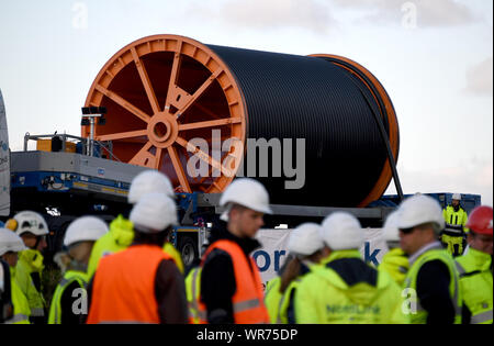 Il 10 settembre 2019, Schleswig-Holstein, Büsum: un basso-caricatore con un enorme tamburo per cavi è permanente al sito in costruzione. Costruzione della NordLink linea di potenza vicino a Büsum è di continuare. La pipeline, che avrà un costo di circa due miliardi di euro servirà a scambiare le energie rinnovabili tra la Germania e la Norvegia Foto: Carsten Rehder/dpa Foto Stock