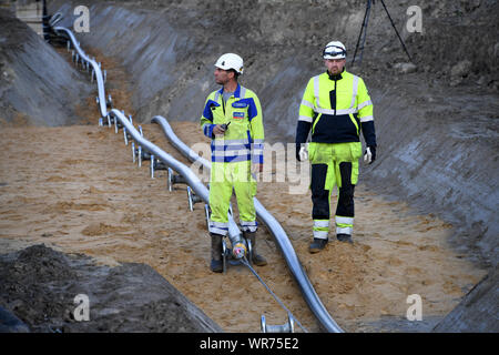 Il 10 settembre 2019, Schleswig-Holstein, Büsum: costruzione i lavoratori sono la posa di una corrente diretta cavo sotterraneo. Costruzione della NordLink linea di potenza vicino a Büsum è di continuare. La pipeline, che avrà un costo di circa due miliardi di euro servirà a scambiare le energie rinnovabili tra la Germania e la Norvegia Foto: Carsten Rehder/dpa Foto Stock