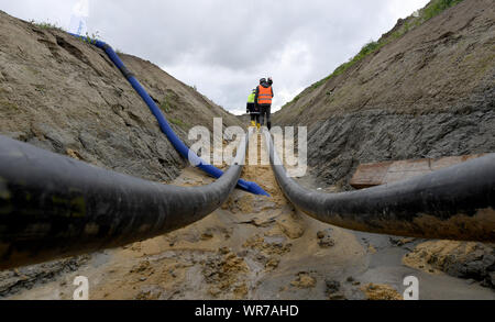 Il 10 settembre 2019, Schleswig-Holstein, Büsum: corrente diretta di cavi interrati eseguire dal terreno per un cosiddetto 'socket stazione". Costruzione della NordLink linea di potenza vicino a Büsum è di continuare. La pipeline, che avrà un costo di circa due miliardi di euro servirà a scambiare le energie rinnovabili tra la Germania e la Norvegia Foto: Carsten Rehder/dpa Foto Stock