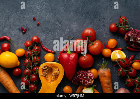 Flatlay con verdure colorate e copia di spazio. Fette di zucca, pomodori ciliegini, peperoni, carote e limoni visto dal di sopra. Un sano Foto Stock