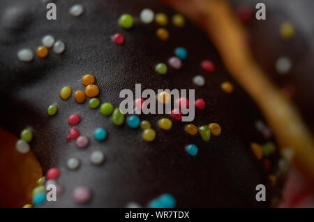 Topping colorati sulla superficie di cioccolato del dessert Foto Stock