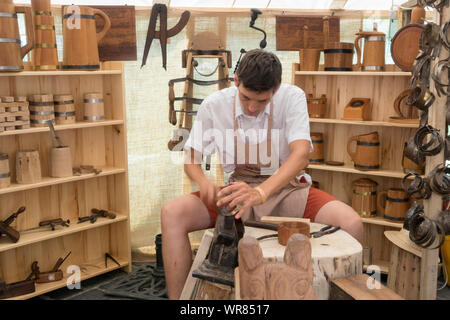 Budapest, Ungheria - 20 AGO 2019: Tradizionale falegname rendendo le tazze di legno al festival di arti popolari nel Castello di Buda, Budapest Ungheria. Foto Stock