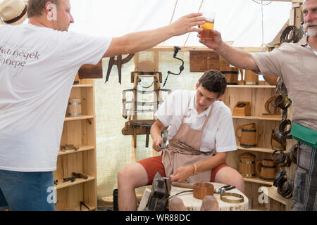 Budapest, Ungheria - 20 AGO 2019: Tradizionale falegname rendendo le tazze di legno al festival di arti popolari nel Castello di Buda, Budapest Ungheria. Foto Stock