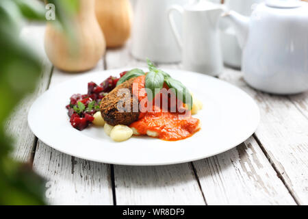 Cotolette di zucca servito con salsa di pomodoro su gnocchi su gnocchi, arrosto Insalata di barbabietole. Foto Stock