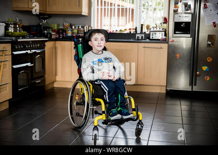 McCrystal Jack che ha un neuro-muscolare di un disturbo che significa che egli è alimentato attraverso un tubo e usa una sedia a rotelle, a casa in Draperstown in Co Londonderry. I genitori di dieci anni che non ha mai assaggiato il cibo hanno accusato il governo britannico di priorità per bambini gravemente ammalati in Inghilterra rispetto a quelli in Irlanda del Nord. Foto Stock