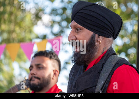 Il batterista Jonny Kalsi dal Dhol Foundation a suonare in un concerto annuale ebraica di musica Klezmer in Regent's Park di Londra UK. Foto Stock