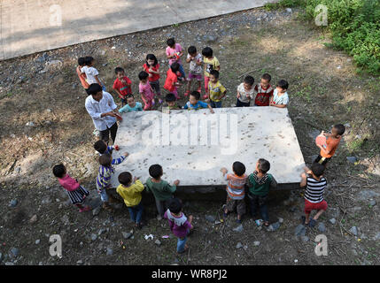 (190910) -- NANNING, Sett. 10, 2019 (Xinhua) -- Professore Huang Yingxiong gioca a Ping Pong con gli studenti durante la pausa a Siye scuola primaria della città Sanshi, Donglan County, a sud della Cina di Guangxi Zhuang Regione autonoma, Sett. 10, 2014. Dal 2012, reporter ha visitato 250 insegnanti in remote zone di montagna nel Guangxi e registrate le loro vite. Gli insegnanti vi riempire sempre di più ruoli come concierge e cuocere. Ci sono circa 16.74 milioni di insegnanti in Cina, 79% surge dalla figura nel 1985 quando la Cina designato sett. 10 come insegnanti" giorno, il Ministero della Pubblica Istruzione ha detto. Un tot Foto Stock