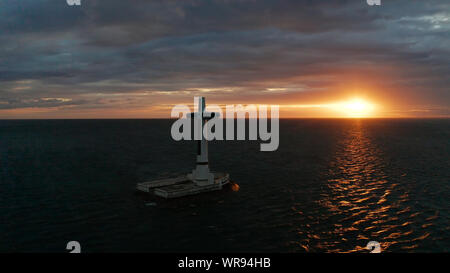 Croce cattolica nel cimitero affondata nel mare al tramonto, Vista aerea. Colorato nubi luminose durante il tramonto sul mare. Tramonto al cimitero affondata Camiguin Island Filippine. Foto Stock