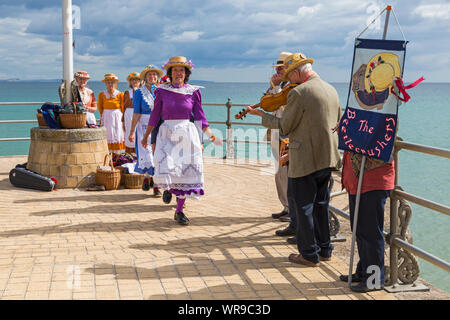 Femmina di intasare i ballerini, membri dell'Beetlecrushers eseguire sul molo di Swanage a Swanage Folk Festival, Swanage, DORSET REGNO UNITO sulla calda giornata di sole nel mese di settembre Foto Stock