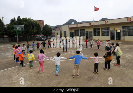 (190910) -- NANNING, Sett. 10, 2019 (Xinhua) -- studenti e due insegnanti giocare durante la pausa a Huguang scuola primaria in Fuchuan Yao contea autonoma, a sud della Cina di Guangxi Zhuang Regione autonoma, Marzo 20, 2019. Qui gli studenti provengono da Hunan e Guangxi come la scuola è situata in corrispondenza della zona di frontiera di Hunan e Guangxi. Due insegnanti sono rispettivamente dalle due aree. Dal 2012, reporter ha visitato 250 insegnanti in remote zone di montagna nel Guangxi e registrate le loro vite. Gli insegnanti vi riempire sempre di più ruoli come concierge e cuocere. Ci sono circa 16.74 milioni teache Foto Stock