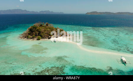 Antenna seascape isola tropicale e spiaggia di sabbia, l'acqua turchese e barriera corallina. malacory isola, Filippine, Palawan. imbarcazioni turistiche sulla Costa Tropical Island. Foto Stock