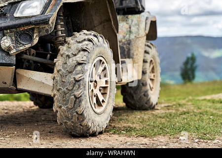 Quadriciclo o quad bike sulle montagne sullo sfondo di un giorno nuvoloso Foto Stock