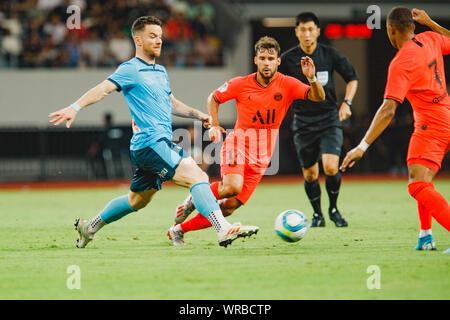 Alexander Baumjohann, sinistra, di Sydney FC sfide Kylian Mbappe, destra e Juan Bernat di Parigi Saint-Germain durante il loro match di Internation Foto Stock