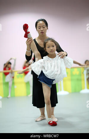 Giovani cinesi i bambini imparare danza presso una scuola durante le vacanze estive in Danzhai county, Qiandongnan Miao e Dong prefettura autonoma, a sud-ovest Foto Stock