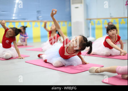 Giovani cinesi i bambini imparare danza presso una scuola durante le vacanze estive in Danzhai county, Qiandongnan Miao e Dong prefettura autonoma, a sud-ovest Foto Stock