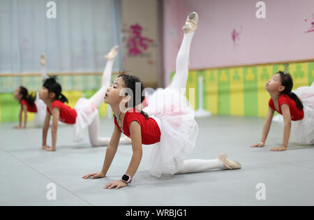 Giovani cinesi i bambini imparare danza presso una scuola durante le vacanze estive in Danzhai county, Qiandongnan Miao e Dong prefettura autonoma, a sud-ovest Foto Stock