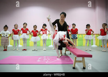 Giovani cinesi i bambini imparare danza presso una scuola durante le vacanze estive in Danzhai county, Qiandongnan Miao e Dong prefettura autonoma, a sud-ovest Foto Stock