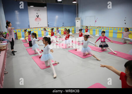 Giovani cinesi i bambini imparare danza presso una scuola durante le vacanze estive in Danzhai county, Qiandongnan Miao e Dong prefettura autonoma, a sud-ovest Foto Stock