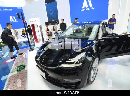 I visitatori di provare o visualizzare un modello di Tesla 3 auto elettrica sul display durante il mondo di intelligenza artificiale Conference 2019 (WAIC 2019) a Shanghai, Chi Foto Stock