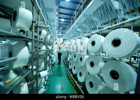 Un lavoratore cinese produce filati di fibra ad una fabbrica tessile di Jiangsu Senjo fibra chimica Co., Ltd. in città Taicang, est della Cina di provincia dello Jiangsu Foto Stock