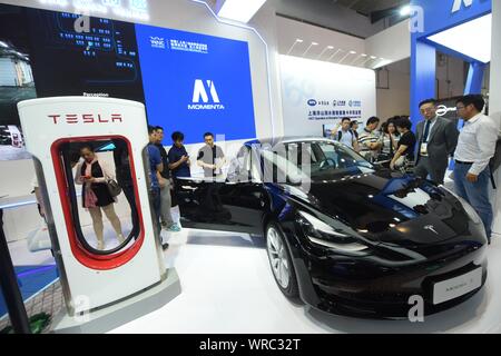 I visitatori di provare o visualizzare un modello di Tesla 3 auto elettrica sul display durante il mondo di intelligenza artificiale Conference 2019 (WAIC 2019) a Shanghai, Chi Foto Stock