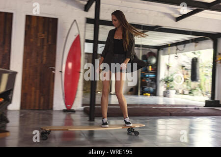 Giovane donna skateboard di equitazione Foto Stock