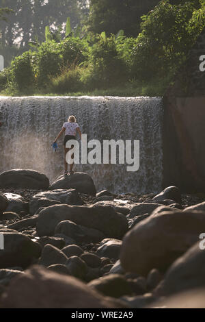 Giovane donna vicino a cascata Foto Stock