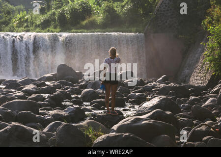 Giovane donna vicino a cascata Foto Stock