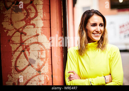 Un ritratto di una donna di atletica in un grintoso ambiente urbano. Foto Stock
