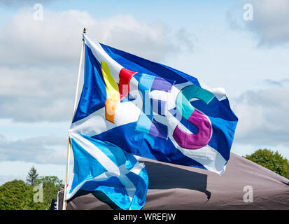 Tutti sotto uno striscione indipendenza (AUOB) rally, Perth, Scotland, Regno Unito. Un colorato sì si intraversa bandiera Foto Stock