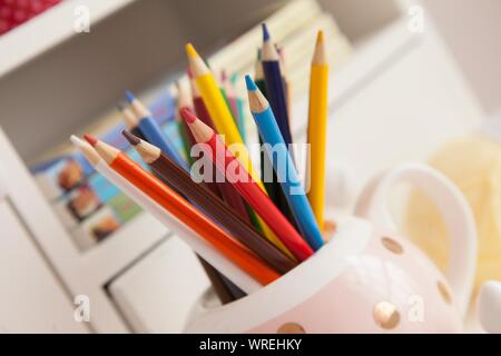 Childs cloured colorate matite memorizzati in una grande tazza bianca. Foto Stock