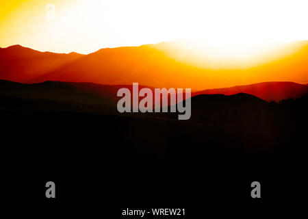 All'alba o al tramonto sulle montagne la gamma della montagna e del cielo Foto Stock