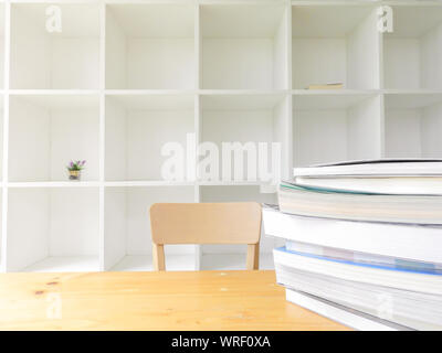 Moderne in legno bianco scaffale con alcuni libri sulla tavola di legno, sullo sfondo della libreria in interni, pulito e moderno decor. Foto Stock