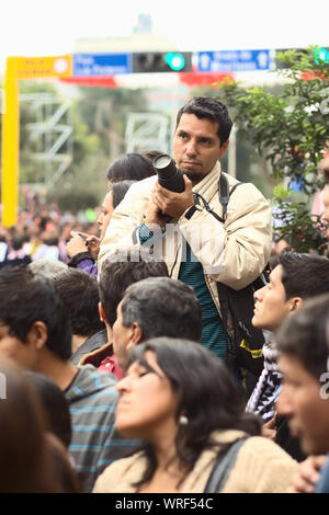 LIMA, Perù - Luglio 21, 2013: Unidentified giovane con una fotocamera reflex digitale sul Wong sfilata in Miraflores sulla luglio 21, 2013 a Lima in Perù. Foto Stock