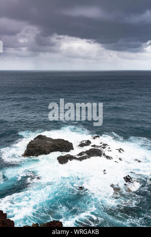 La tempesta e la pioggia con onde alte di colpire le scogliere a Playa de Nogales in La Palma, Spagna. Foto Stock