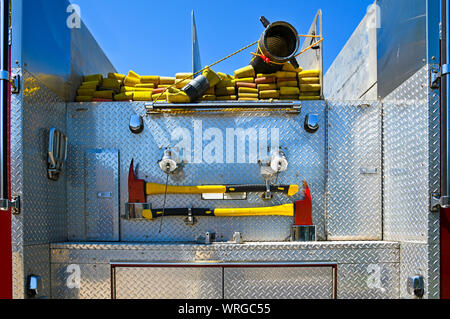 Close-up immagine della parte posteriore di un camion dei pompieri con tubo antincendio e di assi di emergenza Foto Stock