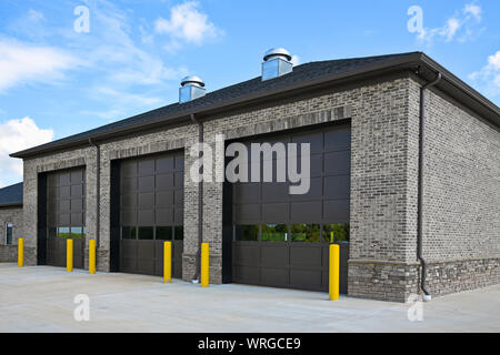 Un nuovo mattone edificio commerciale con tre grandi porte di garage Foto Stock