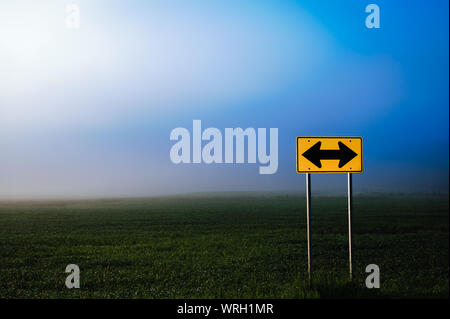 Direzionale segno su strada di fronte ad un campo di mais, Stowe Vermont, USA Foto Stock